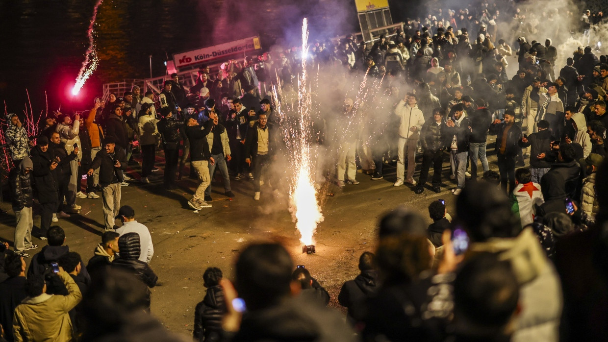 Männer zünden in der Böllerverbotszone in der Düsseldorfer Altstadt Feuerwerk.