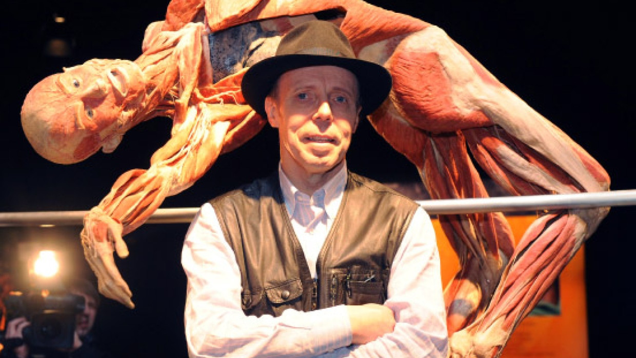 Ausstellungsmacher Gunther von Hagens vor einer plastinierten Hochspringer-Figur