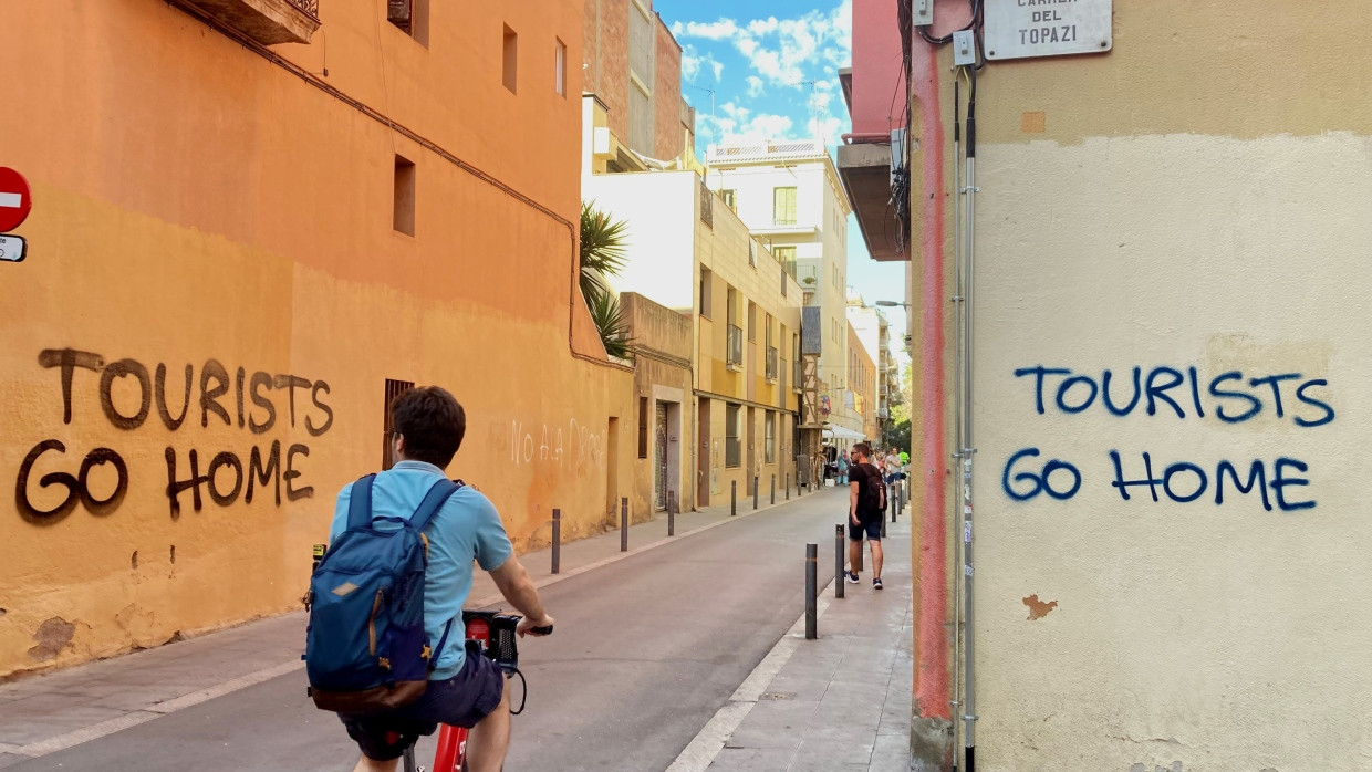 Ein an eine Wand im Künstlerviertel Vila de Gràcia gesprühter Schriftzug „Tourists Go Home“ in Barcelona.