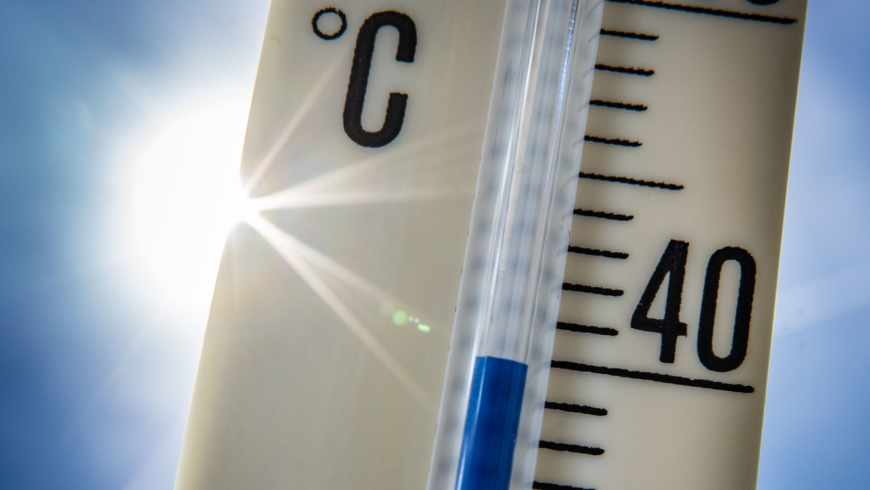 Ein Thermometer wird gegen die Sonne gehalten und zeigt eine Temperatur von 40 °C.