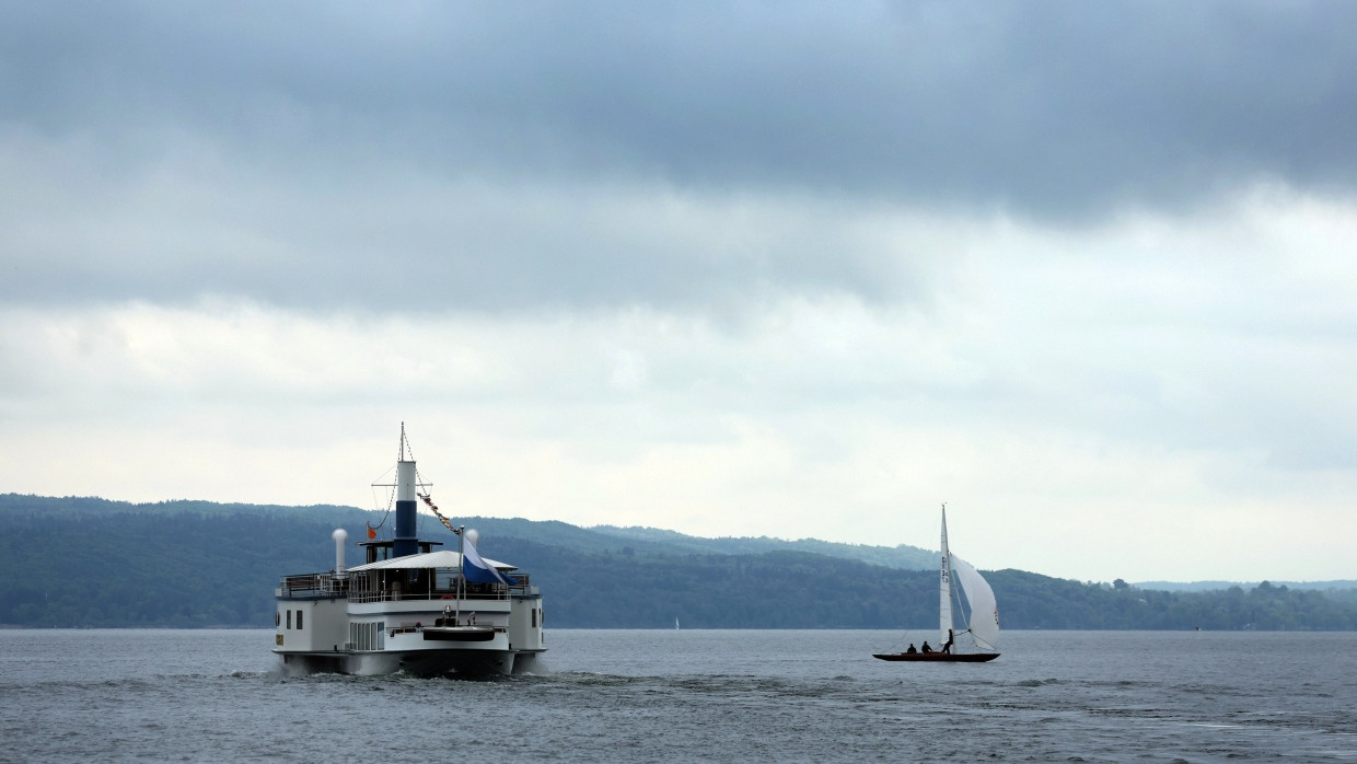 Ein Ausflugsdampfer und ein Segelboot fahren über den wolkenverhangenen Ammersee: Durchwachsenes Wetter zum Wochenbeginn, am Mittwoch klart es auf.