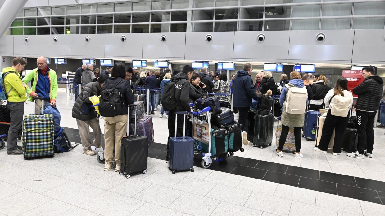 Reisende warten auf den Check-in am Düsseldorfer Flughafen.