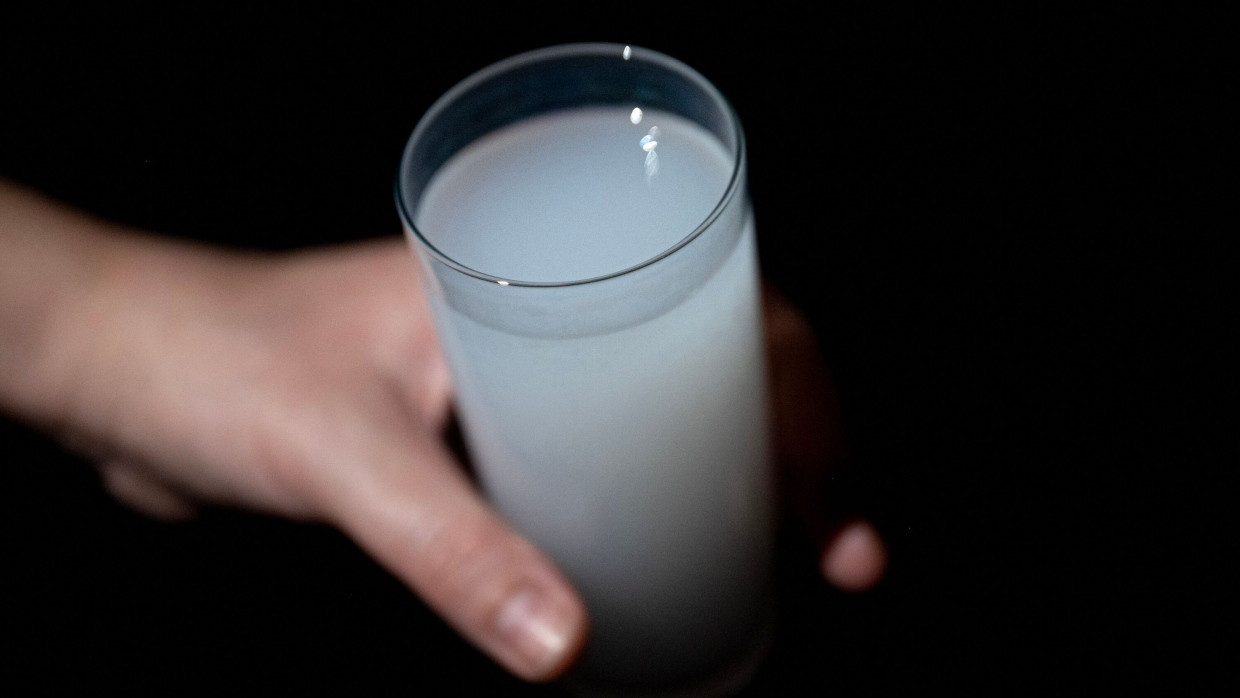 Eine Person hält ein Glas Raki, ein traditionelles Getränk in der Türkei, in der Hand.