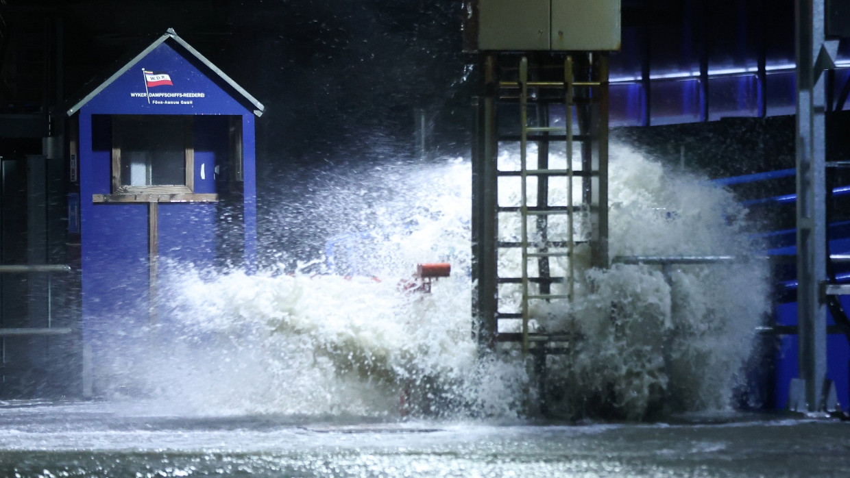 Die Gischt der aufgepeitschten Nordsee überflutet bei Sturm den Fähranleger Dagebüll in Schleswig-Holstein.