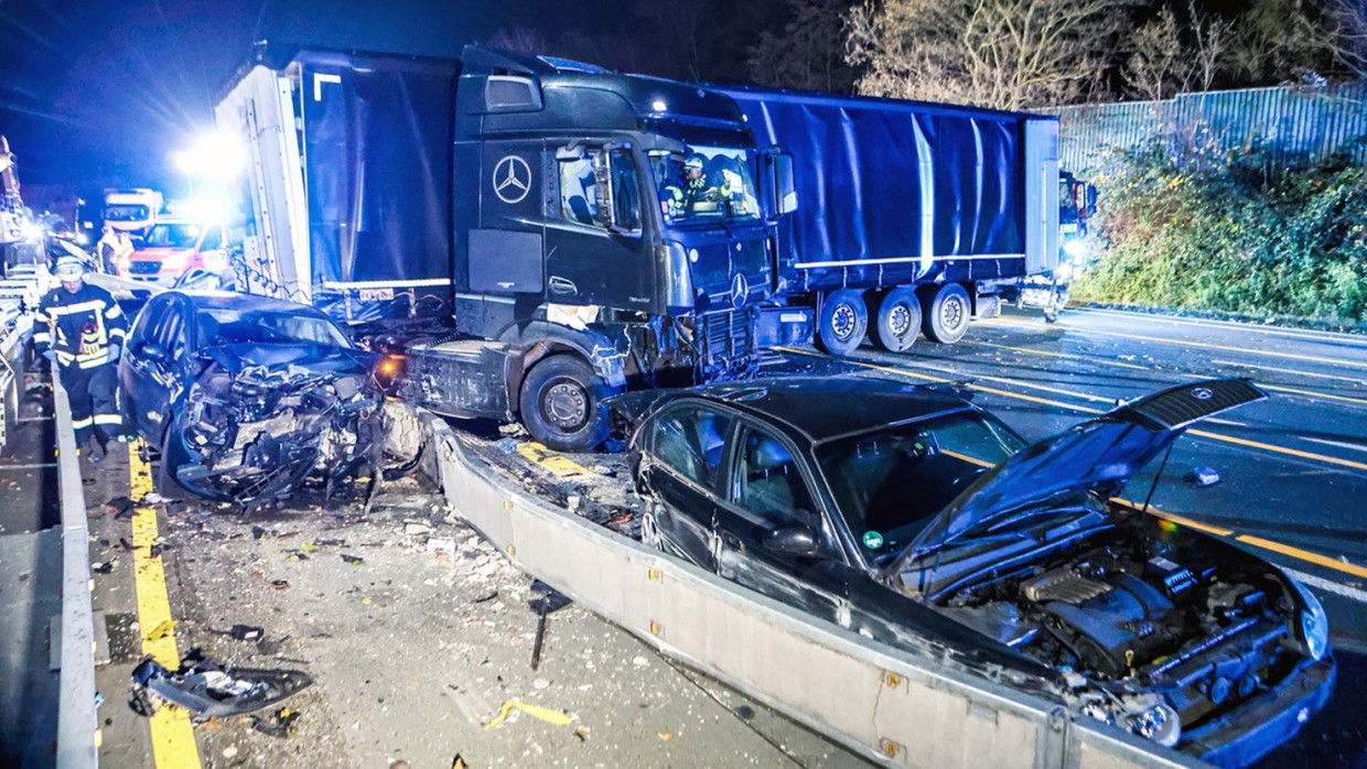 Ein Lastwagen steht auf der Autobahn 1 bei Hagen an der Unfallstelle neben beschädigten Autos. Nach einer Chaosfahrt über mehrere Autobahnen hat die Polizei in Nordrhein-Westfalen einen auffälligen Lkw-Fahrer aus dem Verkehr gezogen. Es habe mehrere Unfälle und Sachschäden gegeben, wie die Polizei mitteilte.