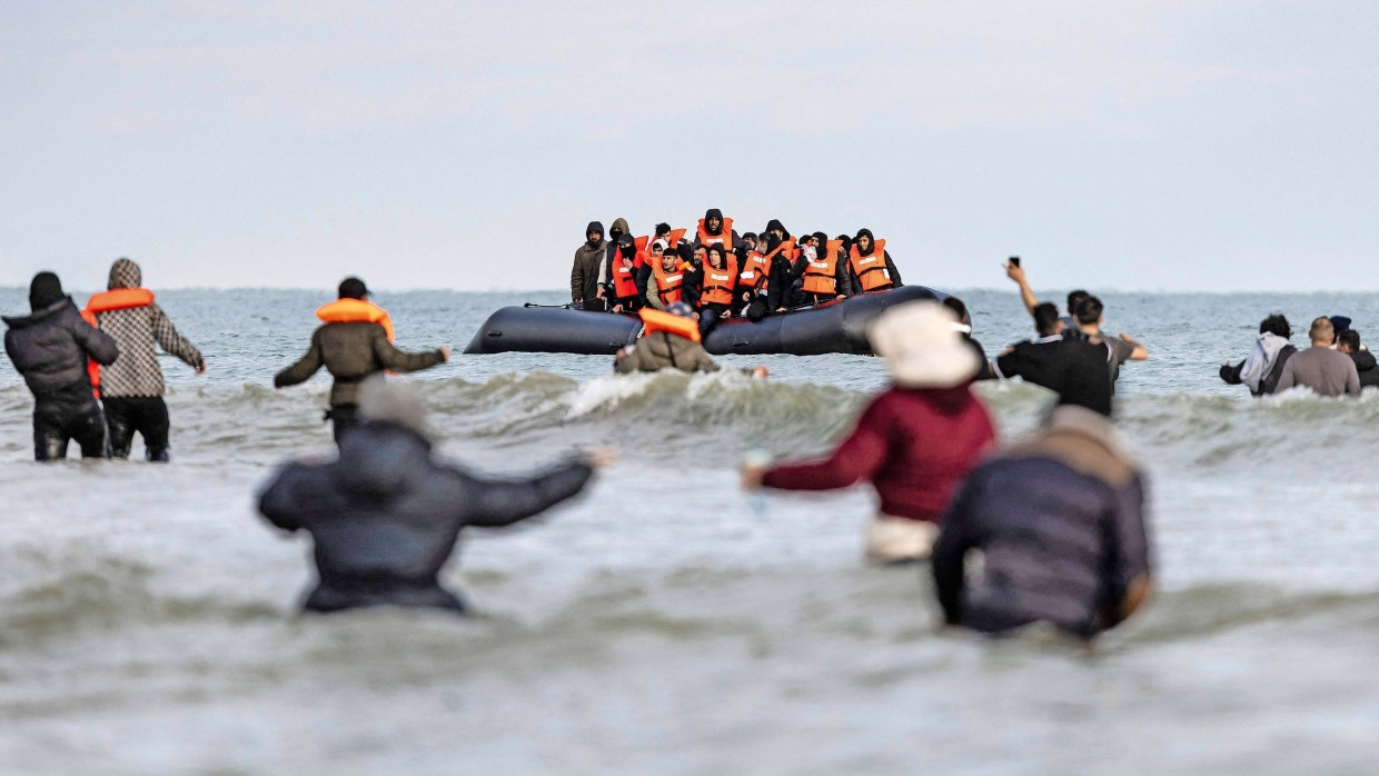 Vor der Überfahrt:
  An einem Strand nahe dem französischen Dünkirchen nehmen Schleuser Migranten  in ein Schlauchboot für die Fahrt über den Ärmelkanal nach Großbritannien.