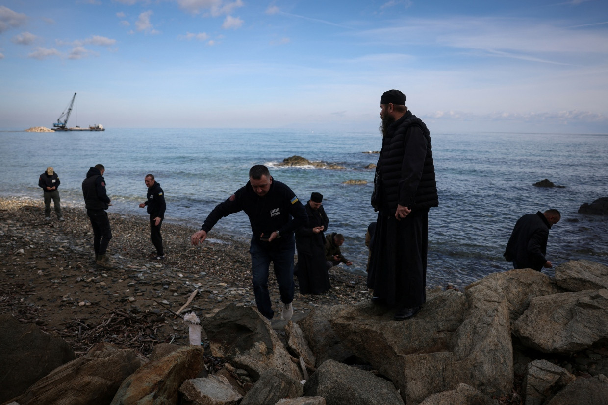 Ukrainische Soldaten sammeln Kieselsteine als Andenken an einem Strand auf Athos.