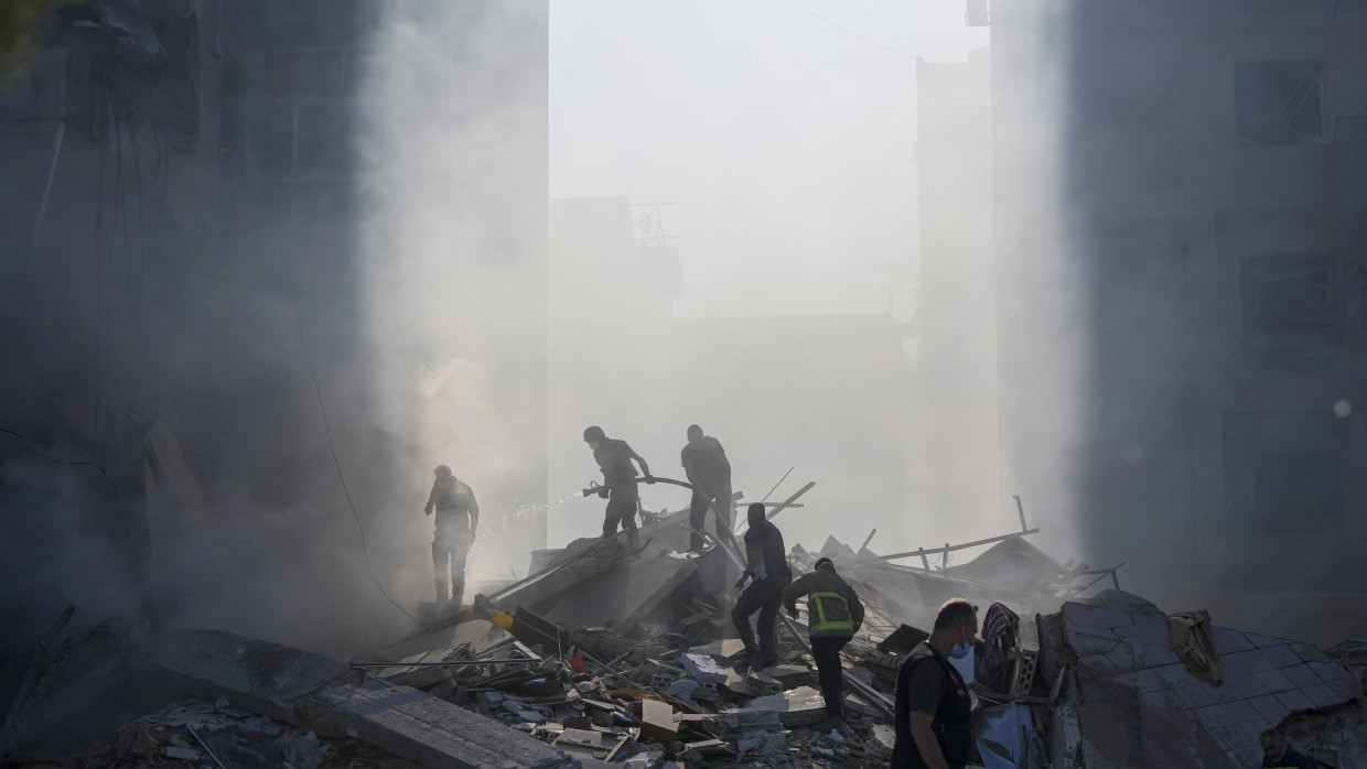 Mitarbeiter des Zivilschutzes löschen Feuer an einem nach einem israelischen Luftangriff zerstörten Gebäude im libanesischen Tayouneh.