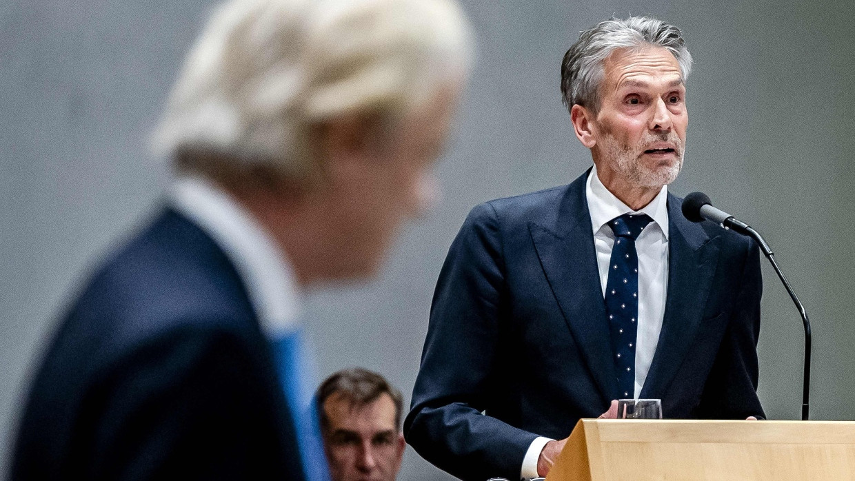 Dick Schoof spricht im Parlament in den Haag. Vor der Kamera läuft Geert Wilders vorbei.