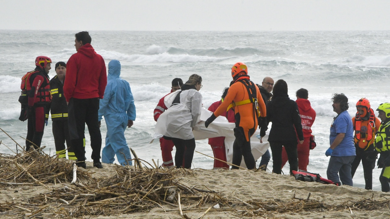 Rettungskräfte bergen eine Leiche an einem Strand in der Nähe von Cutro, Süditalien, nachdem ein Boot mit Migranten bei rauer See auseinandergebrochen war.