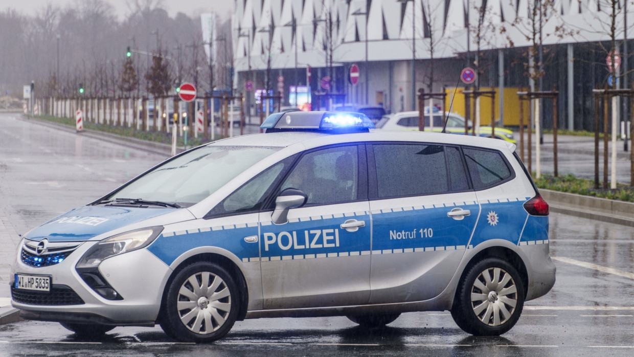 Tatort: Ein Polizeiauto steht vor einer Reihe von Flughafen-Parkhäusern in Frankfurt, wo Ende März ein erschossenes Paar gefunden wurde