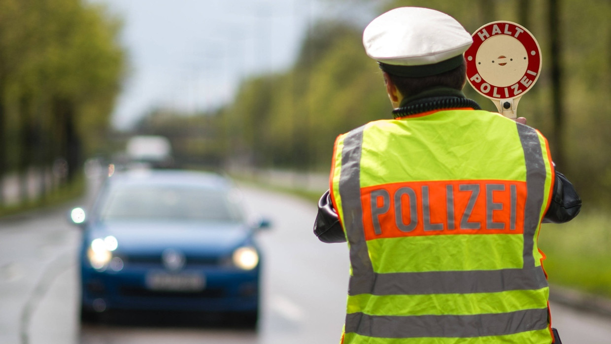 Halt! Ein Polizist stoppt einen Autofahrer, der schneller als erlaubt gefahren ist