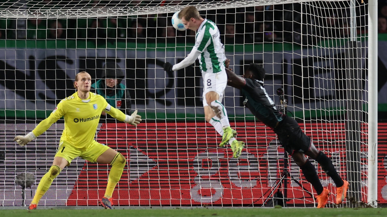 Münsters Torschütze Joshua Mees erzielt den Treffer zum 1:1 gegen Magdeburgs Torwart Dominik Reimann und Daniel Heber.