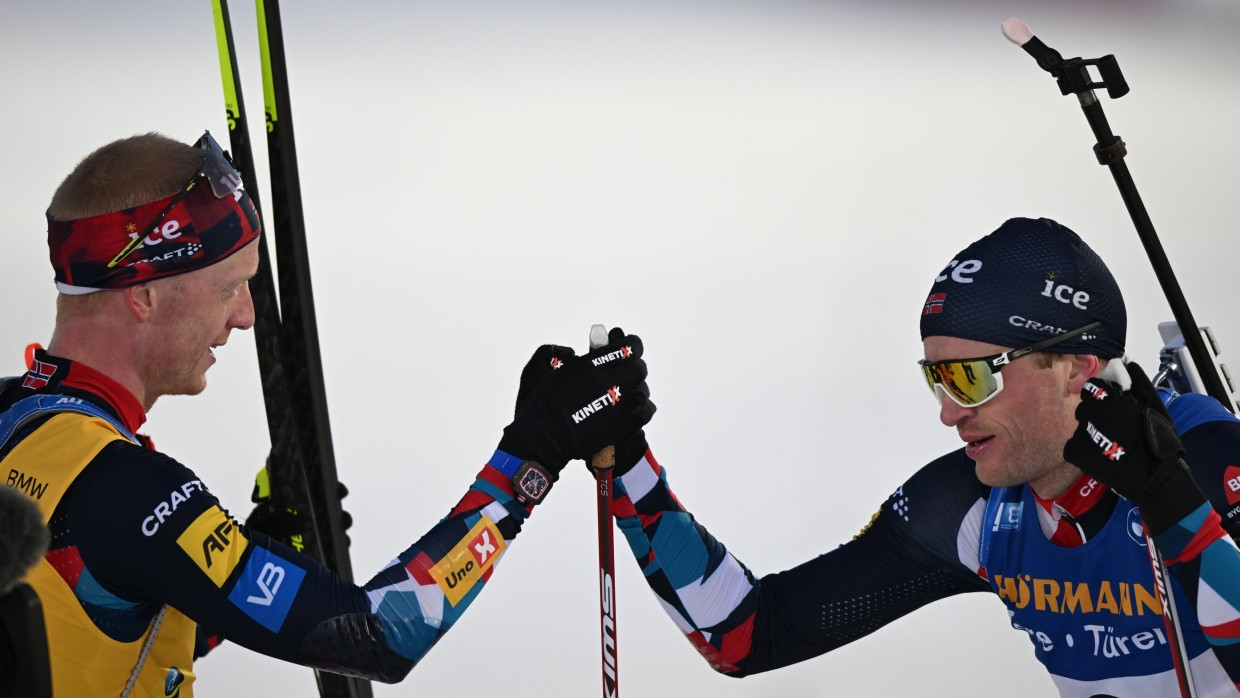 Johannes Thingnes Bö (l) aus Norwegen reicht seinem Bruder Tarjei Bö die Hand.