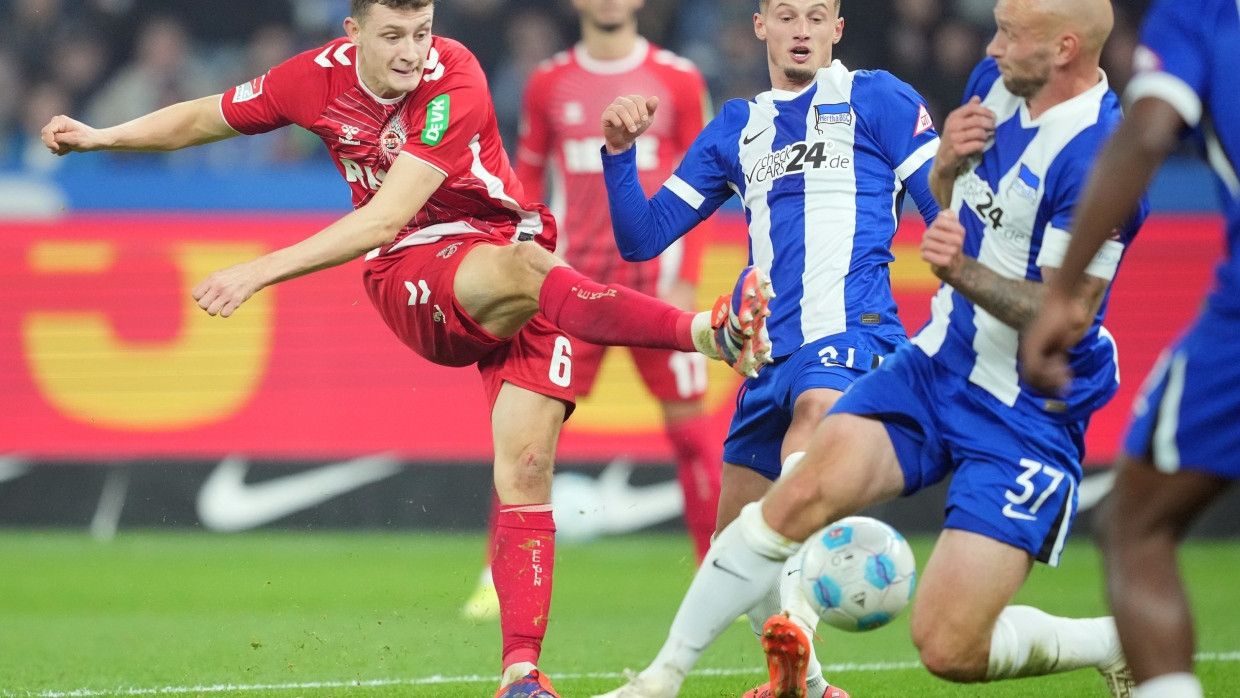 Kölns Eric Martel (l) in Aktion gegen Herthas Spieler Michael Cuisance (M) und Toni Leistner.