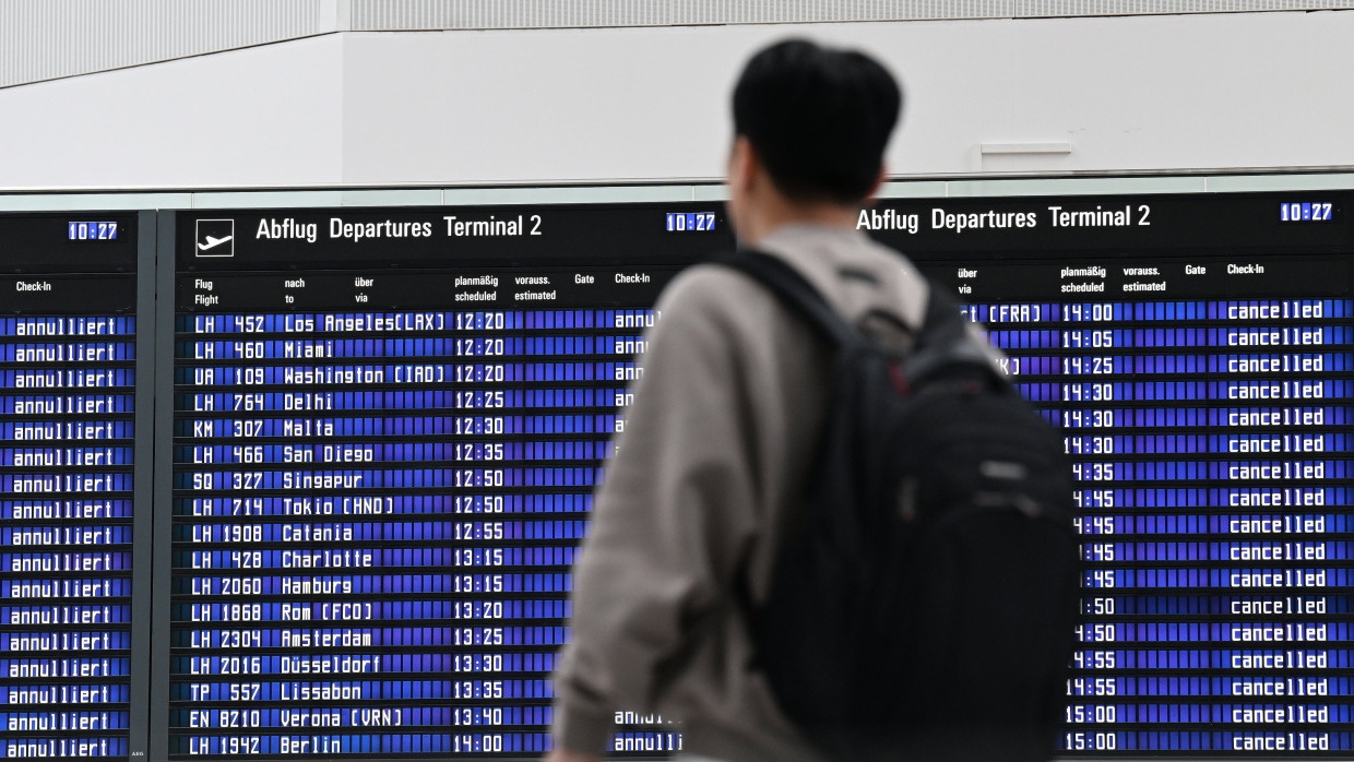 Ein Passagier steht im Münchner Flughafen vor der Anzeigentafel. (Archivbild)