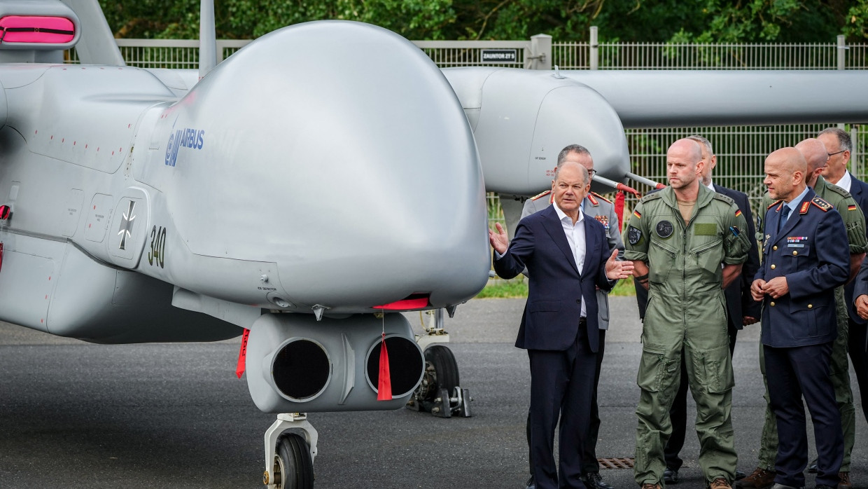 Bundeskanzler Scholz schaut sich auf der Internationalen Luft- und Raumfahrtausstellung auf dem BER-Gelände eine Heron-Drohne an.