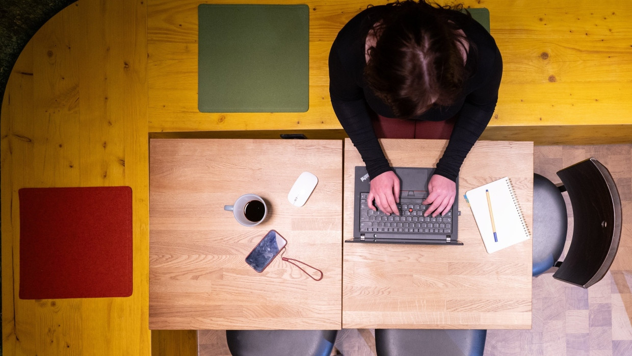 Eine Frau sitzt im Homeoffice am Küchentisch.