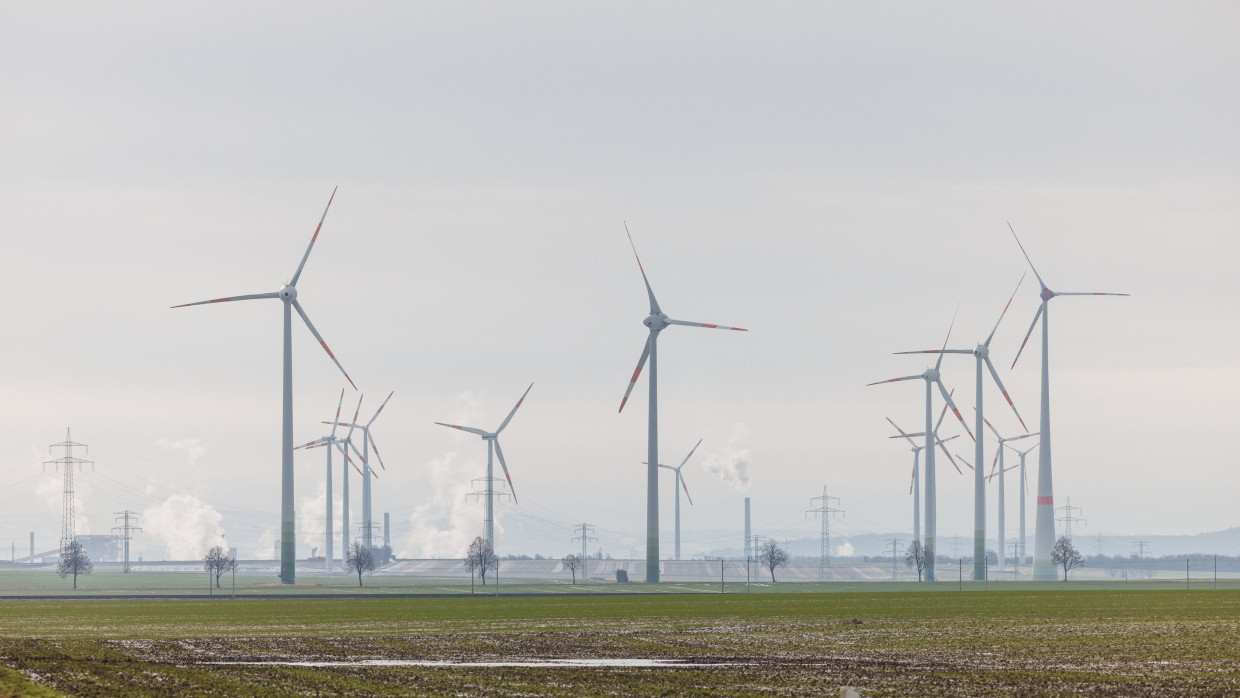 Windräder stehen am Horizont, während im Hintergrund die Schornsteine der Salzgitter AG qualmen.