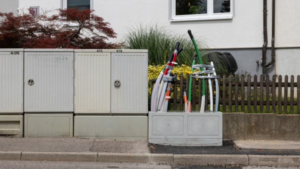 Gut vernetzt? In Friolzheim in Baden-Württemberg ragen am Straßenrand vor einem Wohnhaus Glasfaserkabel aus einem Verteilerkasten.