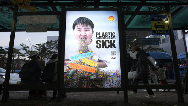 Während der fünfen Verhandlungsrunde für ein UN-Plastikabkommen in Südkorea: Eine Anzeigetafel in Busan mit dem Aufruf, die Plastikproduktion zu senken