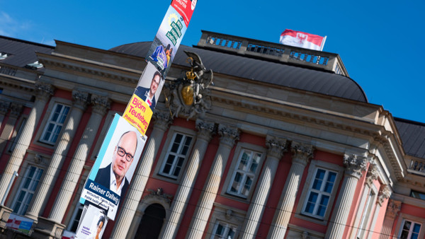 Plakate verschiedener Parteien hängen an einer Straßenlaterne vor dem Brandenburger Landtag.