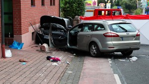 Auto fährt in Gruppe von Feiernden