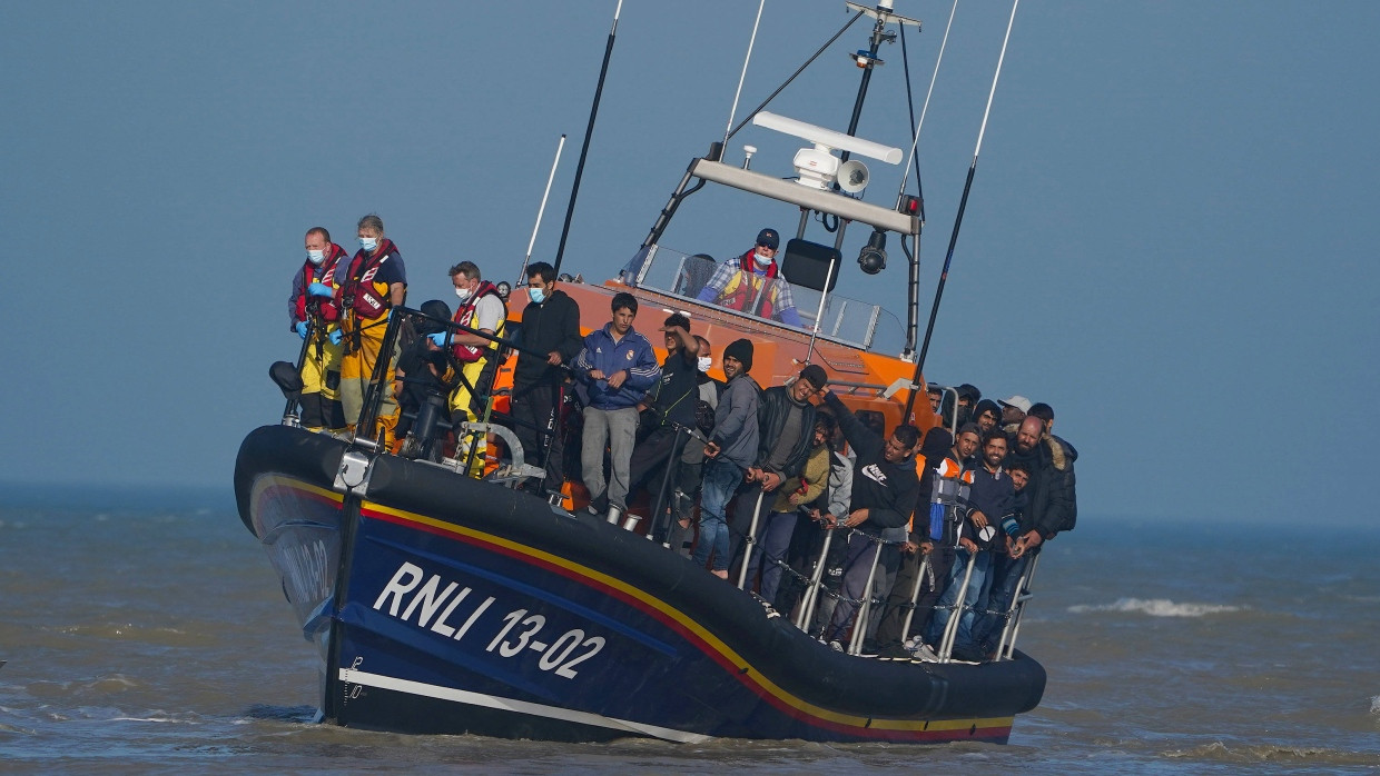 Eine Gruppe vermutlicher Migranten wird nach einem Zwischenfall  am Dienstag mit einem kleinen Boot im Ärmelkanal mit einem Rettungsboot an Land gebracht