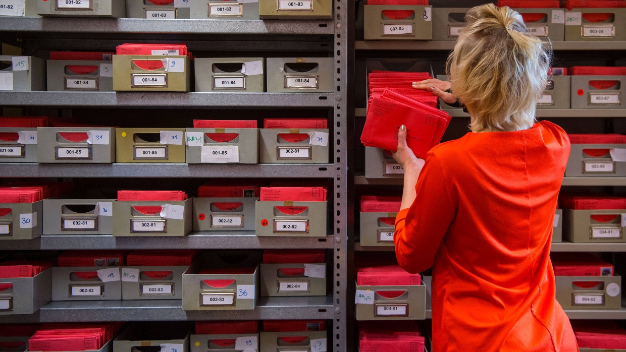 Befristung im öffentlichen Dienst: Eine Angestellte mit Zeitvertrag sortiert Wahlbriefe.