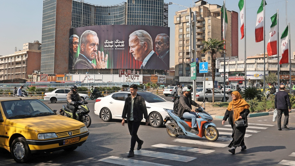 Alltag nach den Angriffen: Verkehr auf den Straßen Teherans vor einem Plakat gegen die USA und Israel