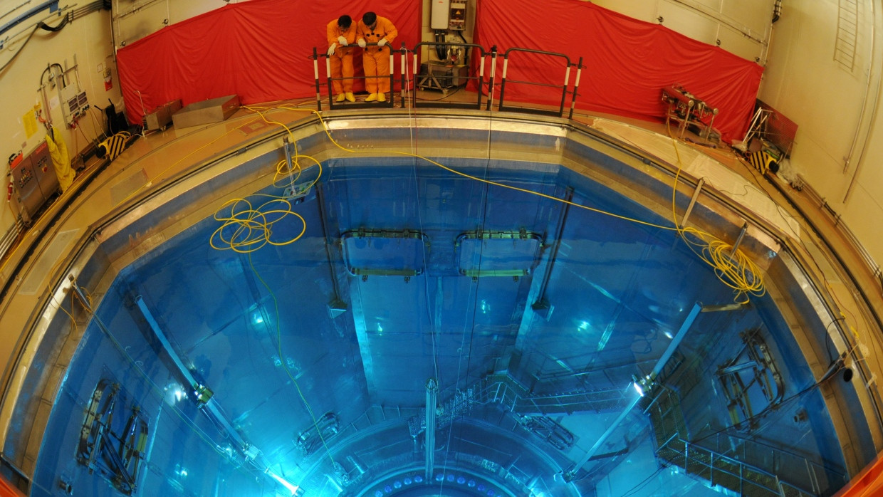 Zwei Männer in Schutzanzügen stehen im Atomkraftwerk Isar 2 in Niederbayern während der jährlichen Revision vor dem geöffneten Reaktordruckbehälter, in dem Brennelemente eingesetzt wurden. (Archivbild)