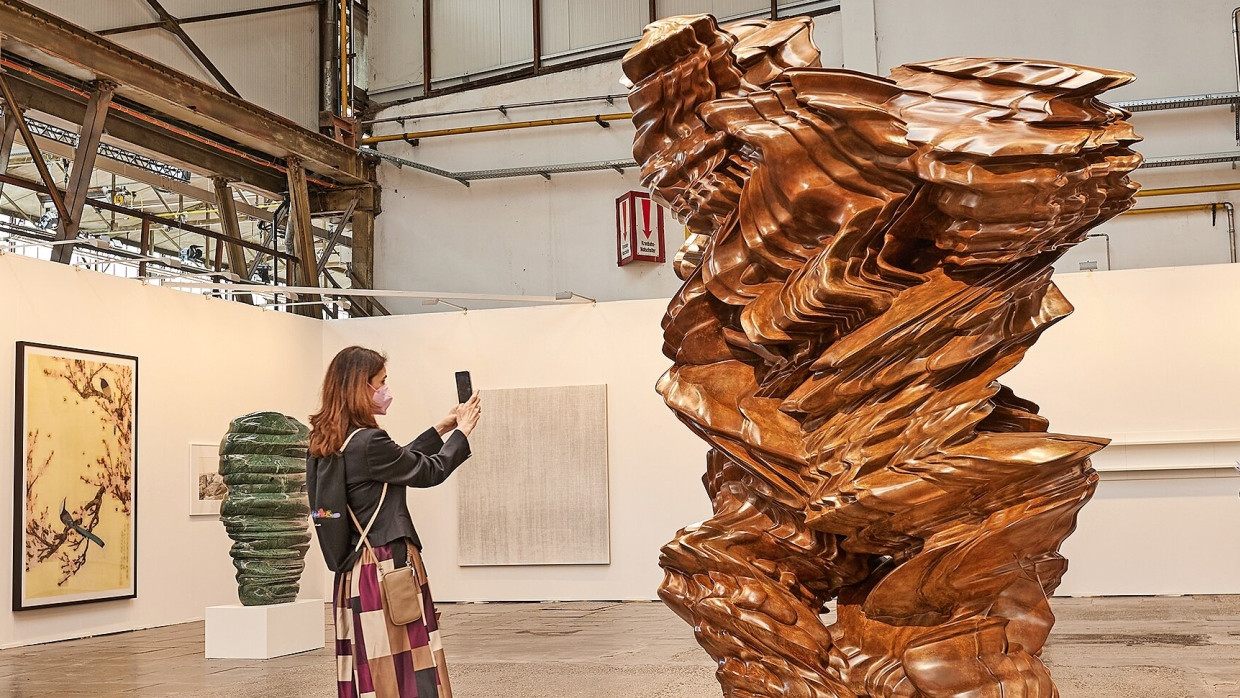 Figuren im Raum: Besucherin der Art Düsseldorf 2022 vor der Bronzeskulptur „Stack“ von Tony Cragg