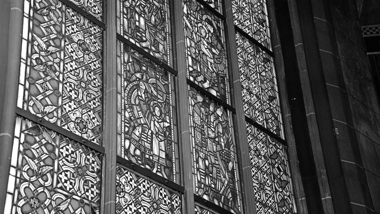 Blick auf Kirchenfenster im St.-Peter-Dom von Worms: in der Mitte das Bild der Maria, die Jesus nach dessen Rückkehr von den Schriftgelehrten umfängt. Hinter ihr im relativen Dunkel stehen zwei durch ihr Aussehen als Juden diskreditierte Figuren.