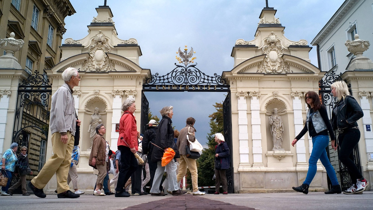 Passanten vor dem Tor zum Campus der Warschauer Universität