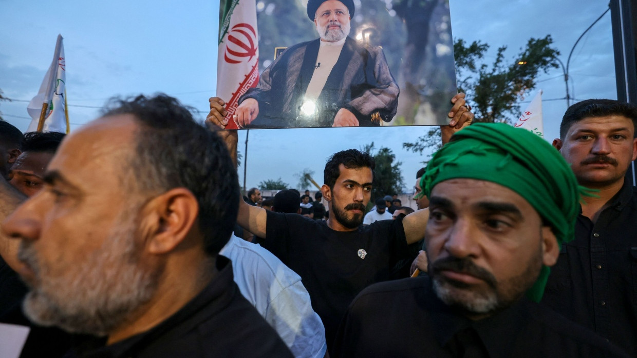 Menschen kondolieren nach dem Tod von irans Präsident Ebrahim Raisi vor der iranischen Botschaft in Bagdad