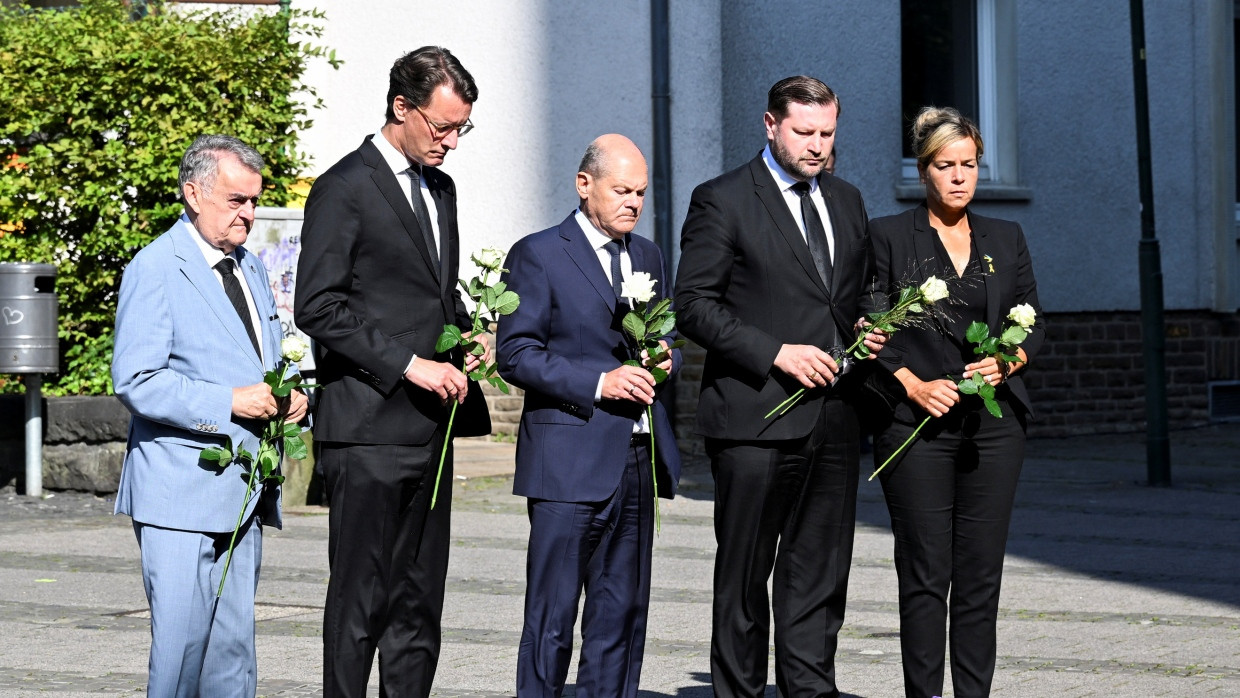 Herbert Reul (CDU), Hendrik Wüst (CDU), Olaf Scholz (SPD), Tim Kurzbach (SPD) und Mona Neubaur (Grüne) legen Rosen am Tatort in Solingen nieder.