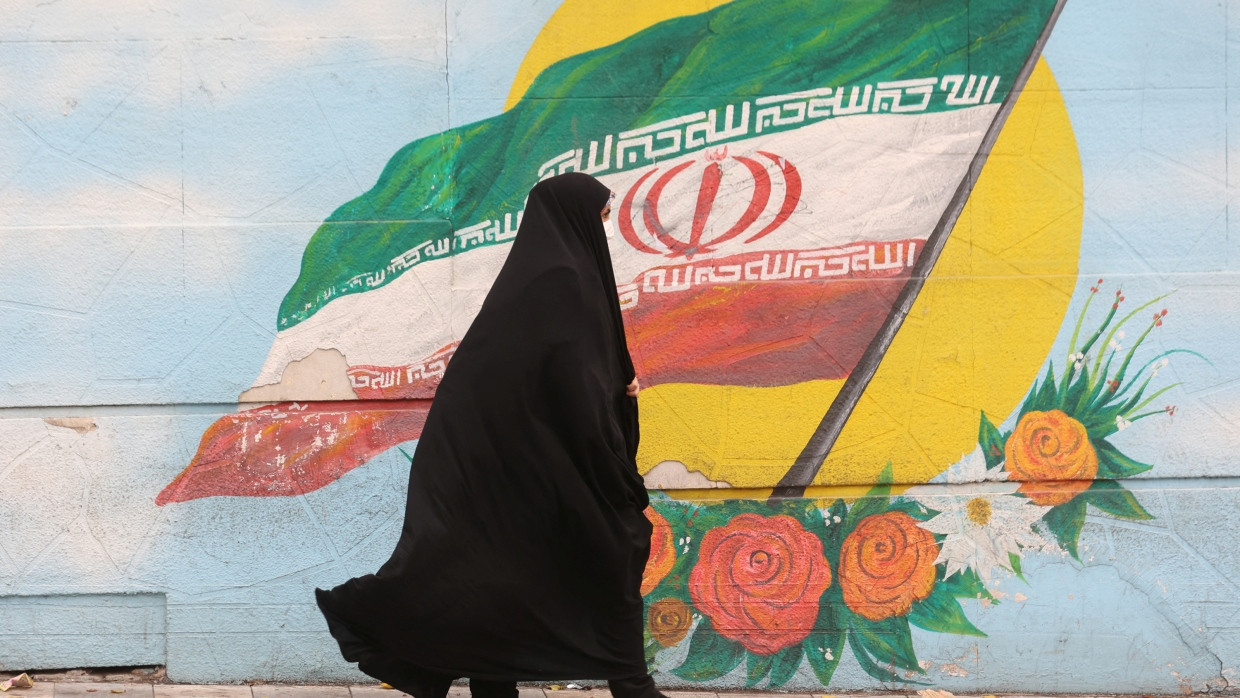 Eine verschleierte Frau geht an einem Wandgemälde in der iranischen Hauptstadt Teheran vorbei. (Archivbild)