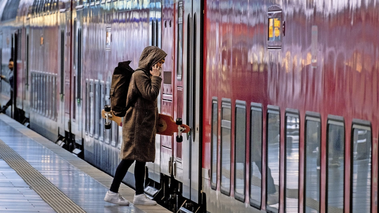 Mit dem Board in die Bahn: Eine junge Frau steigt am Frankfurter Hauptbahnhof in einen Zug.