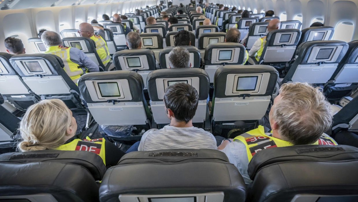 Zwei Polizeibeamte eskortieren einen Afghanen auf dem Flug von Leipzig nach Kabul in einem Charterflugzeug