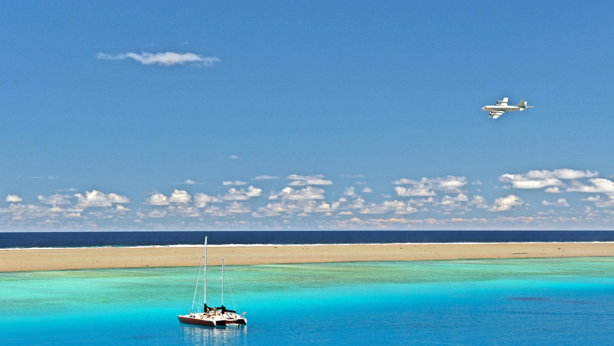 Ein Trimaran ankert am nördlichen Minervariff, einem abgelegenen Atoll im Südpazifik.