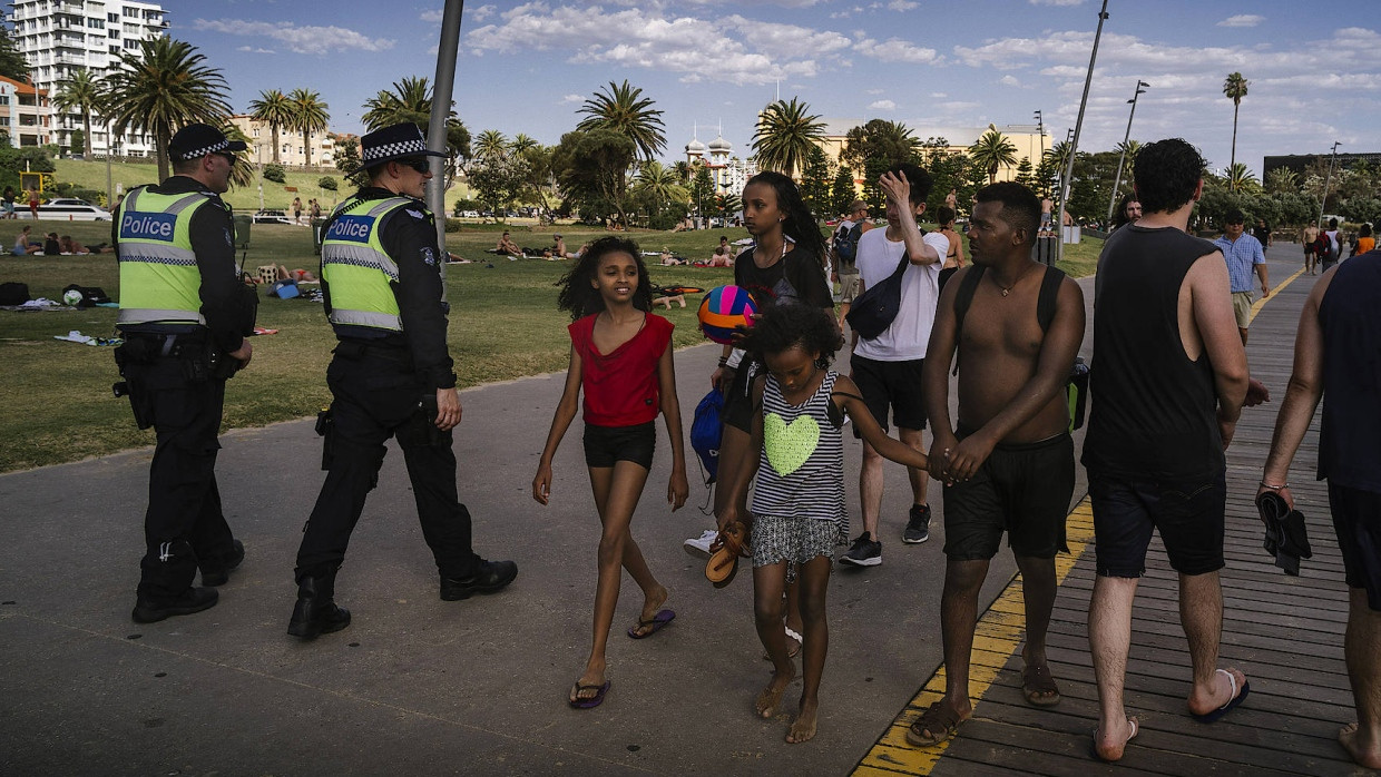 Die afrikanischen Einwanderer stehen an der Uferpromenade von Melbourne unter strenger Beobachtung.