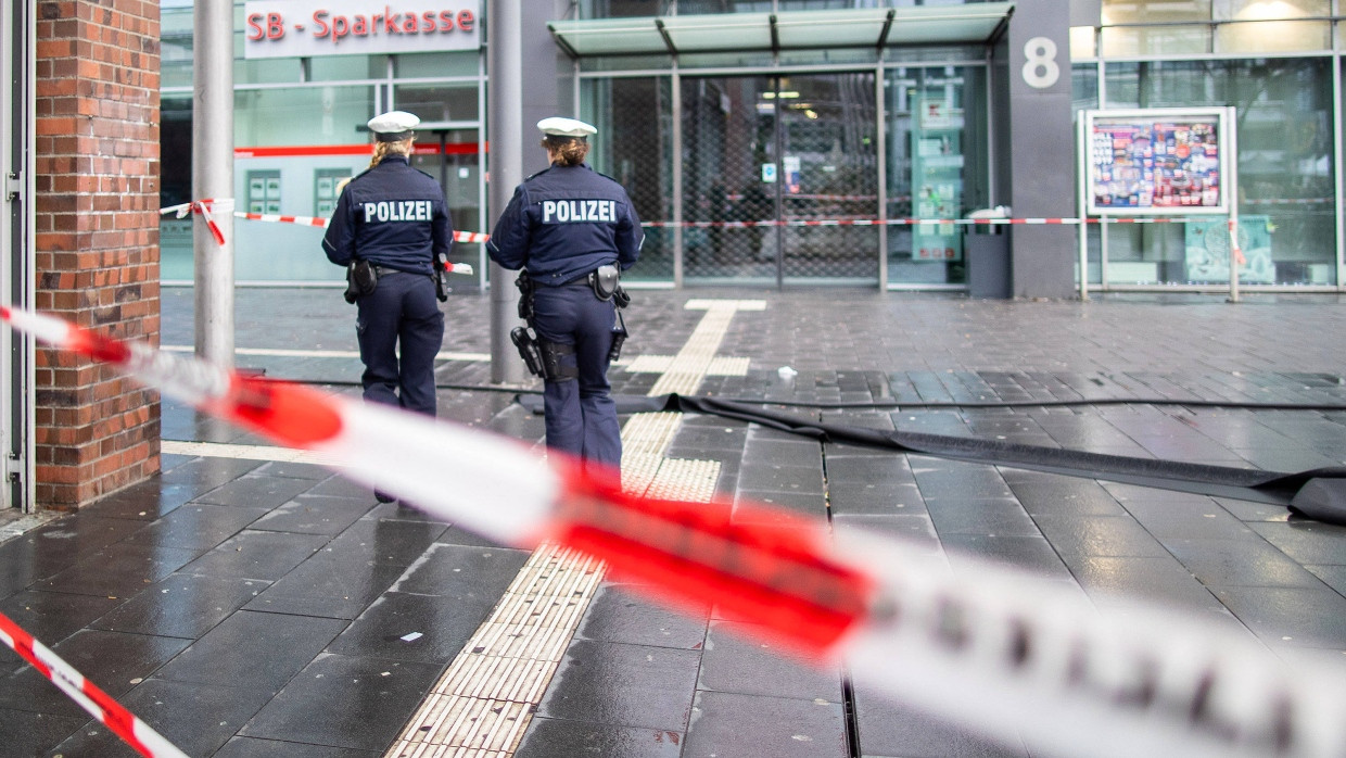 Polizisten laufen an Neujahr hinter Absperrband auf dem Berliner Platz in Bottrop.