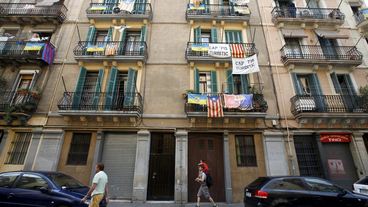 An Balkonen in Barcelona hängen Plakate gegen Ferienwohnungen.