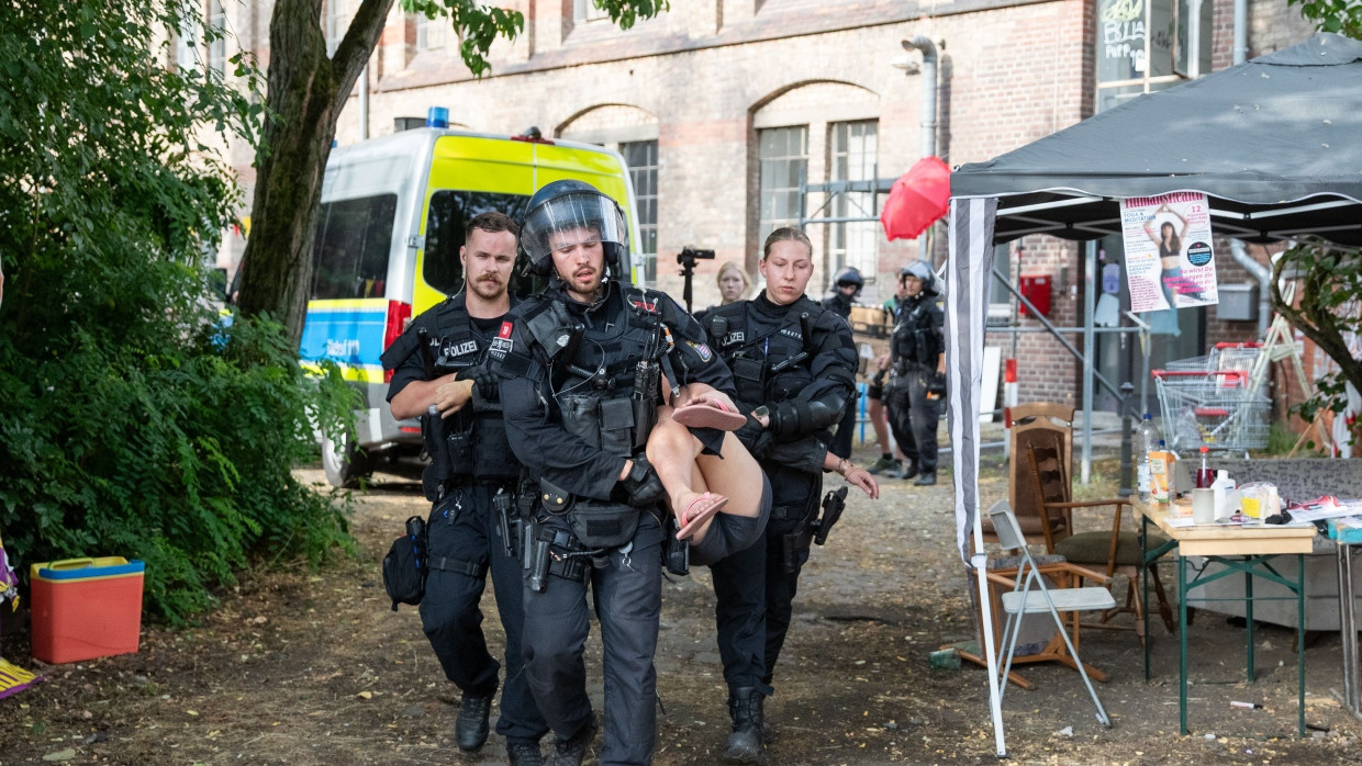 Besetzte Druckerei wird geräumt: Eine Besetzerin wird von Polizeikräften vom Gelände der Dondorf-Druckerei getragen.