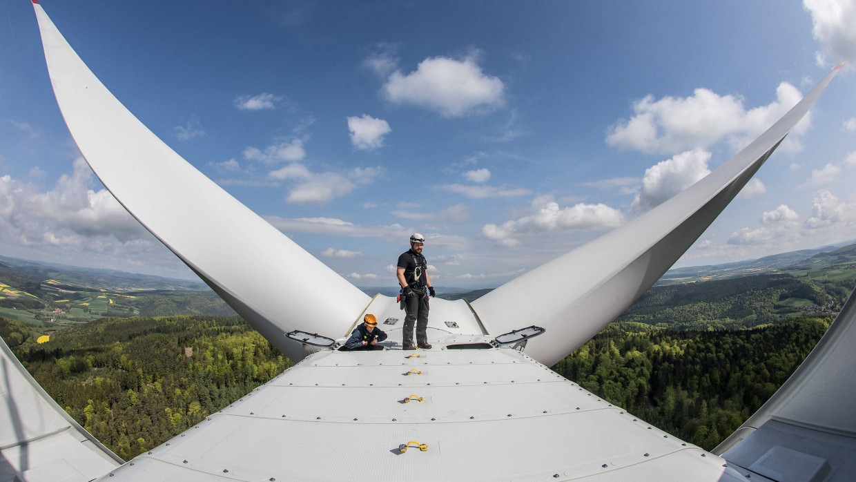 Techniker stehen auf dem Maschinenhaus einer Windkraftanlage vom Typ Vestas V126 in Hessen.