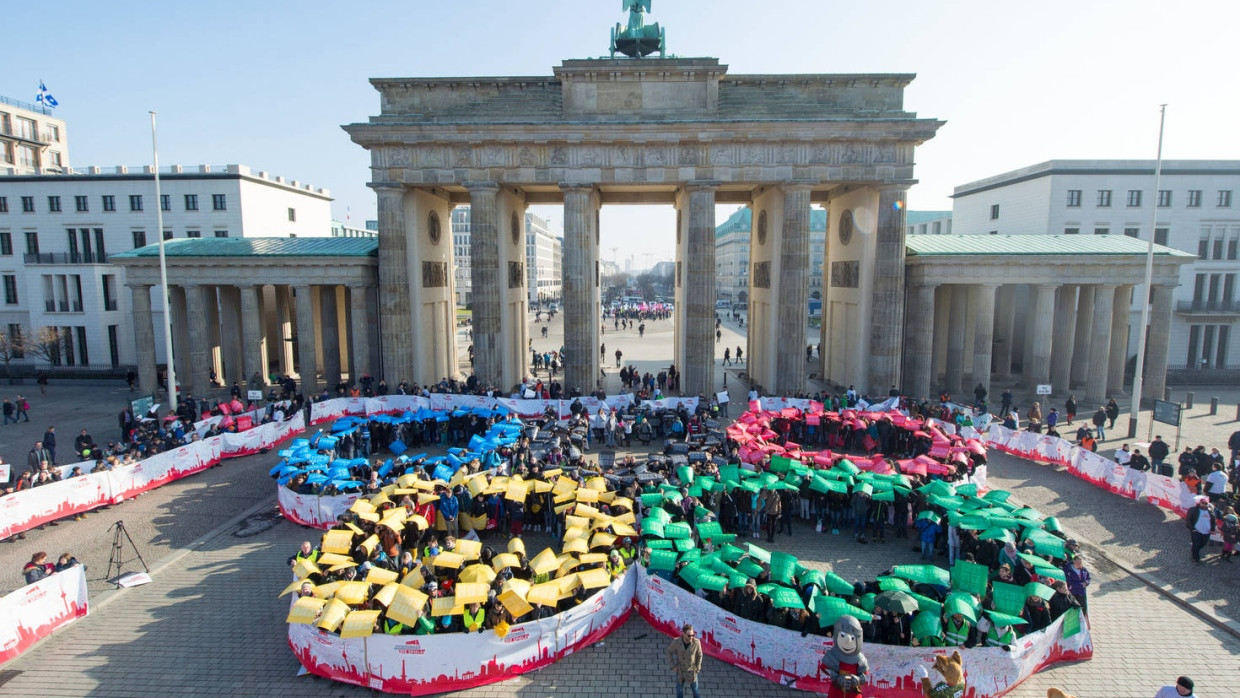 Schüler bilden am 19.02.2015 in Berlin vor dem Brandenburger Tor die Olympischen Ringe nach.