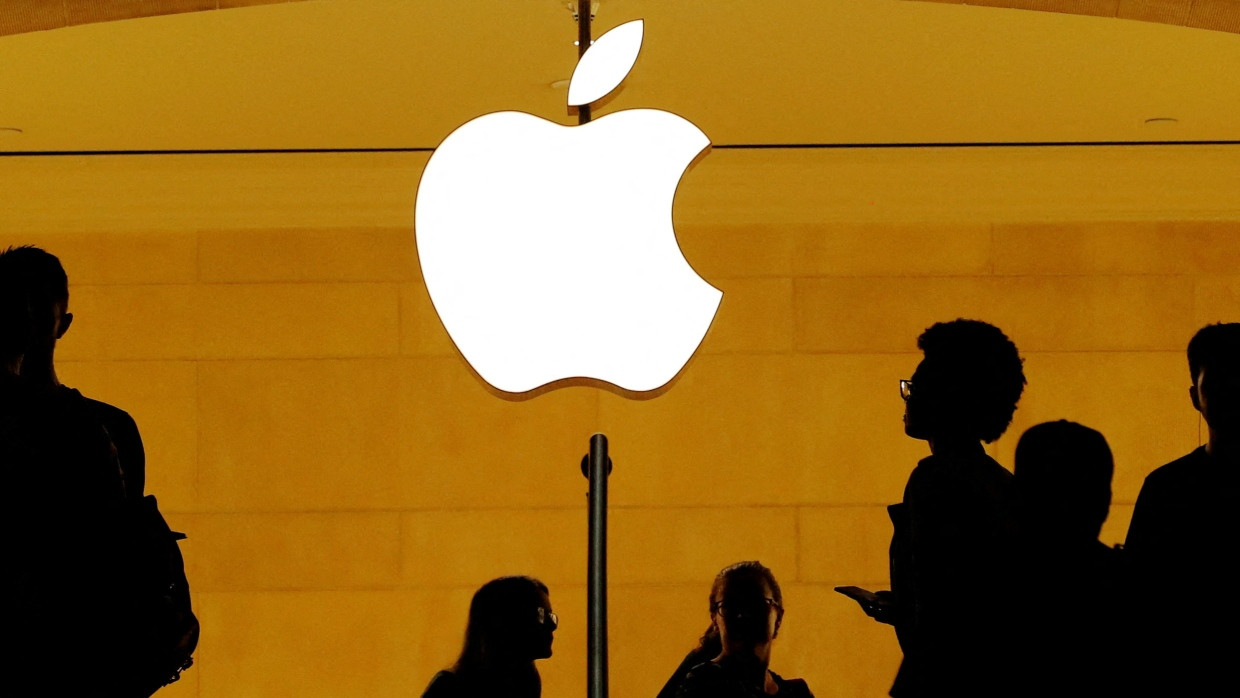 Kunden gehen in einem Apple Store an der Grand Central Station in New York, USA an einem Apple-Logo vorbei.