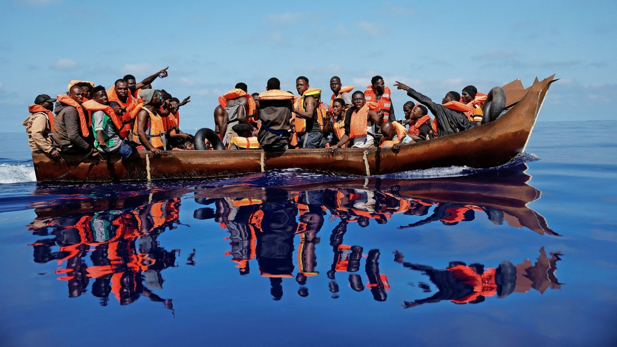 Ein Boot mit Flüchtlingen nähert sich am 11. August im Mittelmeer südlich der Insel Lampedusa dem Rettungsschiff „Astral“ der Hilfsorganisation Open Arms.