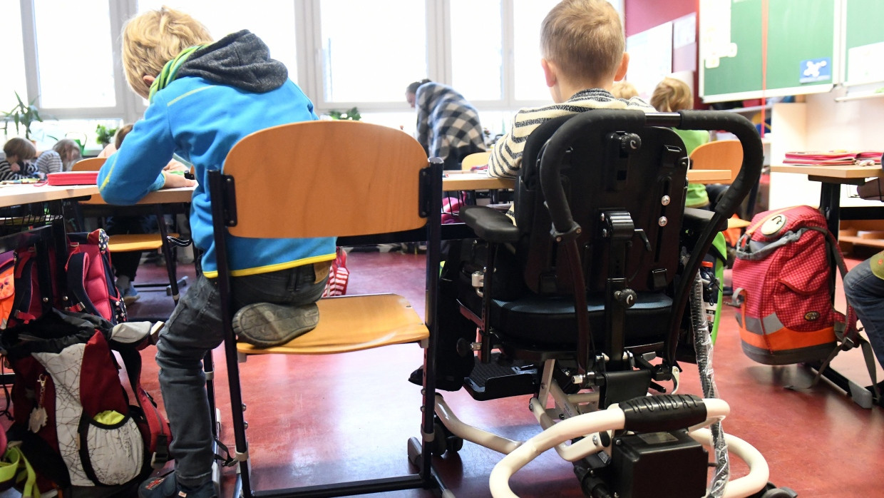 Ein Kind mit Behinderung sitzt in der Rosa-Luxemburg-Grundschule in Potsdam (Brandenburg) in einem Klassenraum.