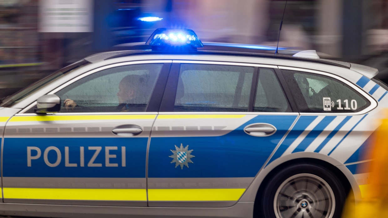 Ein Polizeiwagen fährt mit Blaulicht durch die Münchner Innenstadt.